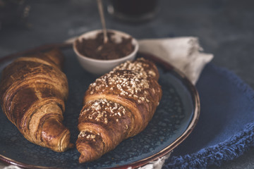 Tasty golden croissants in a plate. Freshly baked croissants. Toned photo