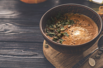 Pumpkin soup on a wooden table. Toned photo. Copyspace