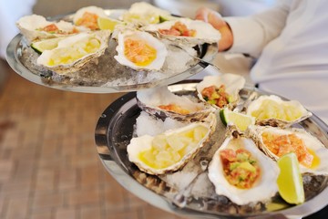 Seafood. Mollusc shellfish. Baked mussels with cheese, cilantro and lemon in oyster shells.