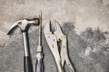 Old steel oxided working tools, Hammer, screwdriver and wrench on cement background
