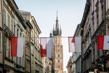 Fototapeta na wymiar Flags on the Szczepańska street with the Basilica of Santa María in the background