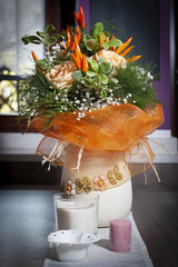 Colored flowers in the vase on dark table, with white centrerpiece and decorative candles