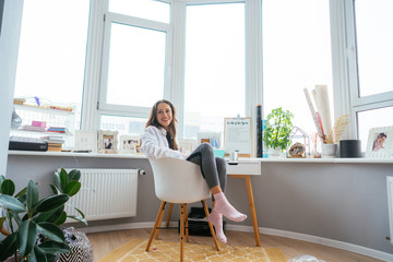 Young woman on chair near the window