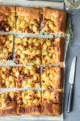 Deliciously grape tart made with puff pastry, caramelized onion, cheese, thyme and green grape. Flatbread with grapes. 