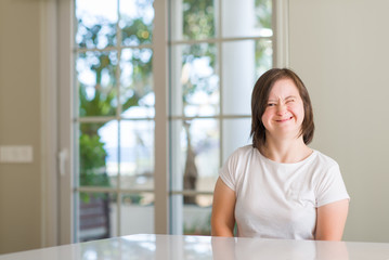 Fototapeta premium Down syndrome woman at home winking looking at the camera with sexy expression, cheerful and happy face.
