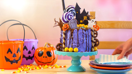On trend Halloween candyland fantasy novelty drip cake in colorful party setting.