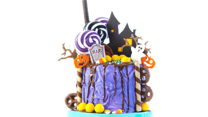 On trend Halloween candyland fantasy novelty drip cake on white background.