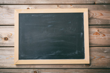 Blank blackboard with frame on wooden wall background