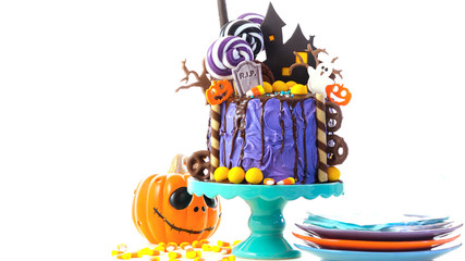 On trend Halloween candyland fantasy novelty drip cake on white background.