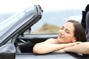 Girl relaxing in a convertible car on vacations
