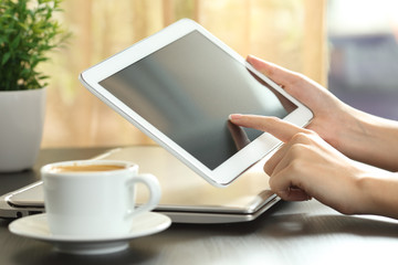 Woman hands touching a tablet screen on a table