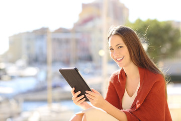 Woman looking at camera holding a tablet