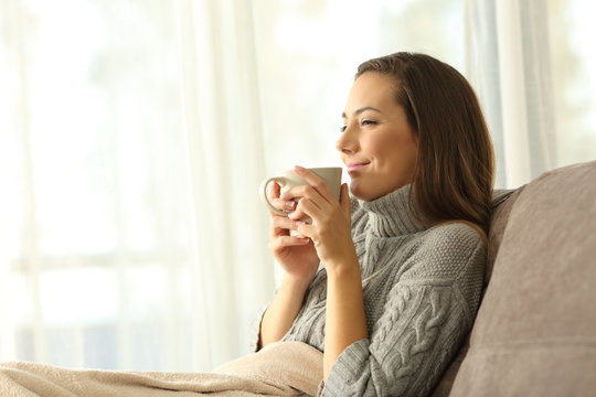 Woman enjoying a cup of coffee in winter at home