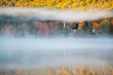 Misty Lake in New England at Sunrise surrounded by fall color