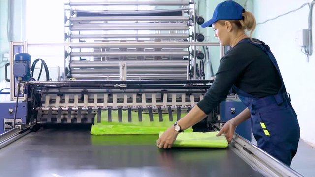 woman worker in the production of plastic packaging folds finished products