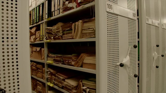 In an archive the camera moves out a shelf inside relocation shelves. The image can be used for the integration of archive texts in films and reports. Thanks to the 50 frames it can be slowed down.