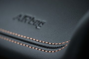Detailed image of a dashboard airbag zone leather stitch work.