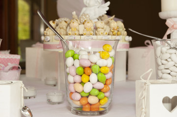 Colourfully sugared almond, inside glass vase and background slightly out of focus