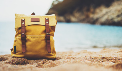 background blue sea ocean horizon, hiker tourist yellow backpack on sand beach, blurred panoramic seascape blank, traveler relax holiday concept, sunlight view in trip vacation