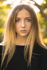 Naklejka premium Beautiful serious concentrated girl student posing in the park outdoors on grass looking camera.