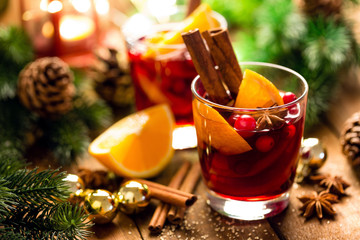 Christmas mulled red wine with spices and oranges on a wooden rustic table. Traditional hot drink at Christmas