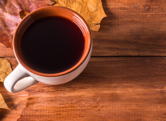 Cup of coffee surrounded by autumn leaves autumn concept.