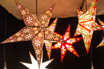 Illuminated Christmas fair kiosk with loads of shining decoration merchandise, with glittering...