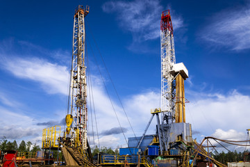 Oil and Gas Drilling Rig onshore dessert with dramatic cloudscape. Oil drilling rig operation on...