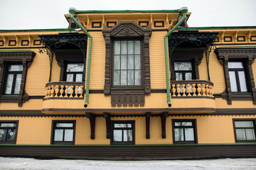 Obraz premium Facade of the yellow wooden house in winter in Arkhangelsk, Russia