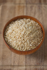 Brown rice in a bowl on wooden ыгкафсу
