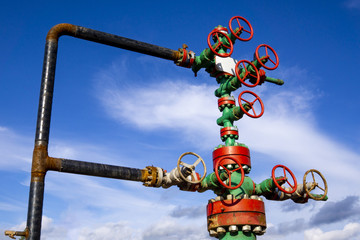 Horizontal view of a wellhead with valve armature. Oil and gas industry concept. Industrial site...