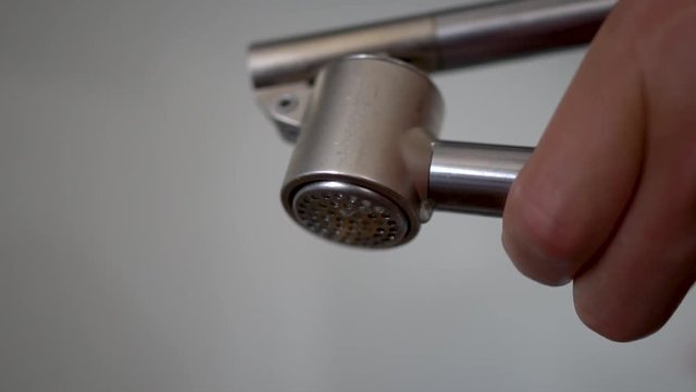 Macro shot of squeezing garlic out of garlic press