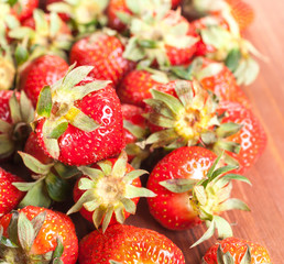 Fresh red strawberry close-up on a wooden background