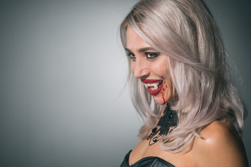 vampire woman with a bloody mouth and teeth fangs celebrating a devilish holiday happy halloween