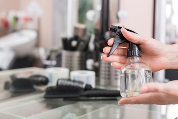 A woman hairdresser holds in her hand a  hair on the background of a hairdresser