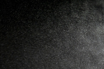 Mysterious, Solemn, Hazy fog patterns lit by a beam of light. Ray of scenic spot light over dark background, stage illumination equipment. Smoke over black background.