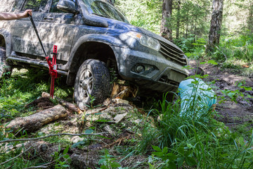 Fototapeta na wymiar Use of a jack when an off-road vehicle hits an obstacle