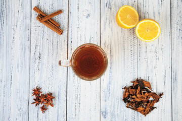 Cup of tea, lemon, cinnamon, cloves, dried tea leaves