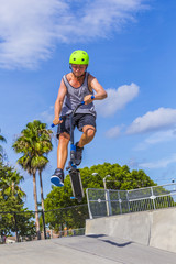 boy has fun riding his push scooter at the skate park