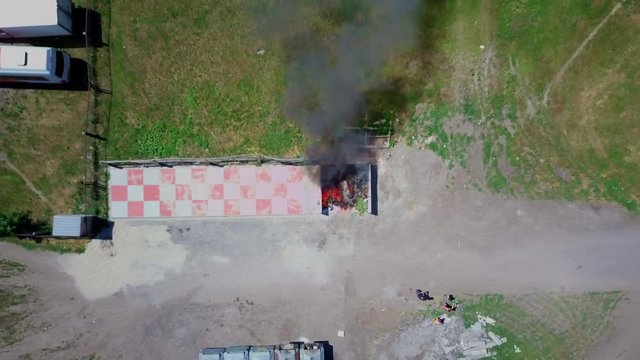Firefighters extinguish burning garbage can, aerial