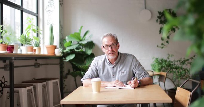 Portrait of mature businessman working in a cafe
