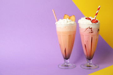 Glasses of tasty milk shakes and space for text on color background