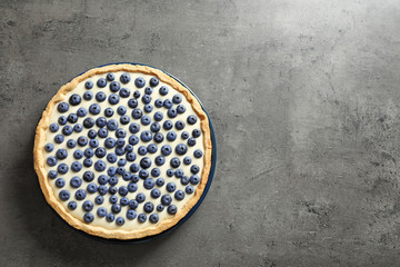 Tasty blueberry cake on gray background, top view with space for text