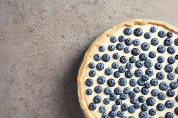 Tasty blueberry cake on gray background, top view with space for text