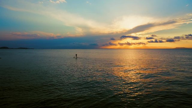 A man goes to the soup by the sea during a beautiful sunset