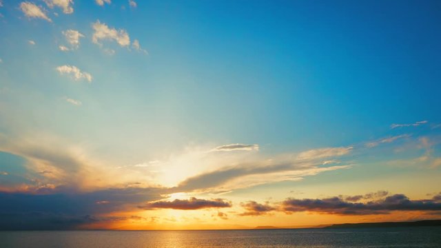 Sea view on a pleasant summer evening: a beautiful sunset, colored clouds, a pure sea with a yacht, the glint of the sun on the water. Sea, ocean, natural video for tourist, resort and meditative site
