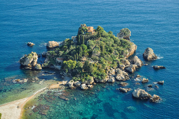 Small rocky island surrounded by blue waters off shores of Europe (Greece).