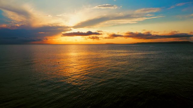 Sea view on a pleasant summer evening: a beautiful sunset, colored clouds, a pure sea with a yacht, the glint of the sun on the water. Sea, ocean, natural video for tourist, resort and meditative site
