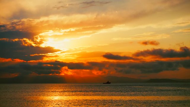 Sea view on a pleasant summer evening: a beautiful sunset, colored clouds, a pure sea with a yacht, the glint of the sun on the water. Sea, ocean, natural video for tourist, resort and meditative site
