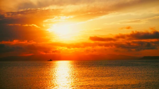 Sea view on a pleasant summer evening: a beautiful sunset, colored clouds, a pure sea with a yacht, the glint of the sun on the water. Sea, ocean, natural video for tourist, resort and meditative site